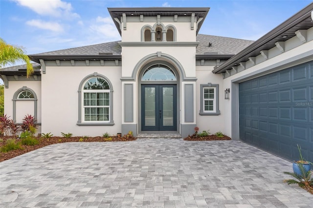 view of exterior entry featuring french doors and a garage