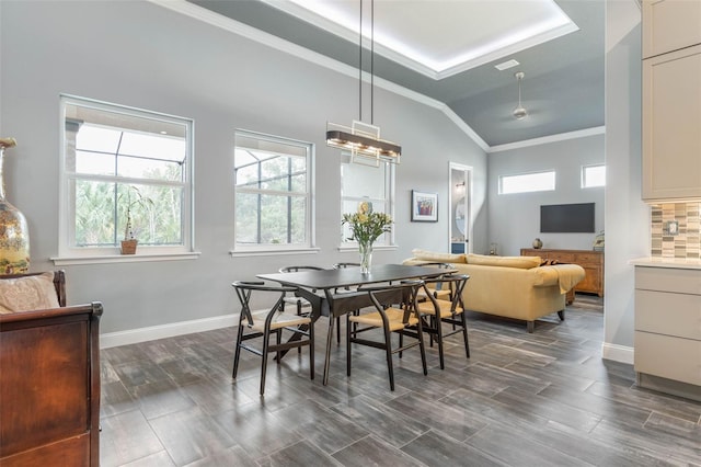 dining area featuring vaulted ceiling, a raised ceiling, crown molding, and dark hardwood / wood-style floors