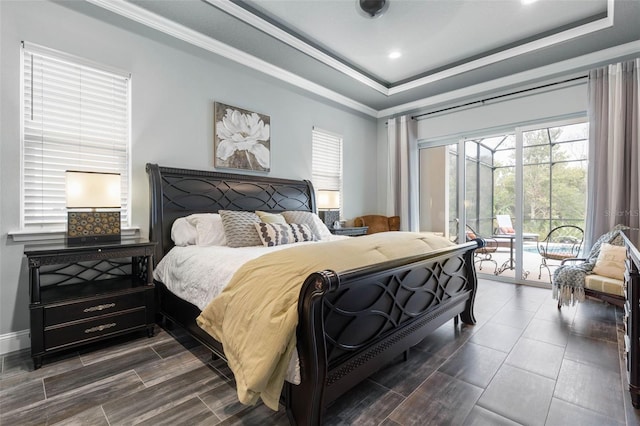 bedroom featuring access to exterior, a raised ceiling, and crown molding