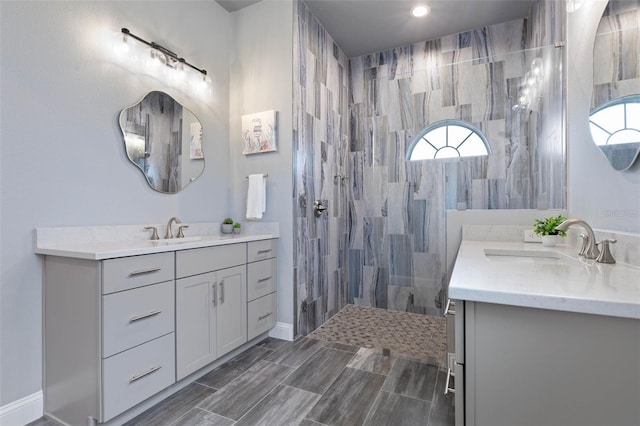 bathroom featuring tiled shower and vanity