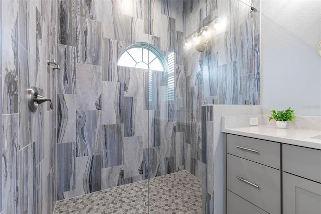 bathroom with vanity and tiled shower