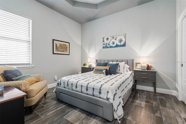 bedroom with multiple windows and dark hardwood / wood-style flooring