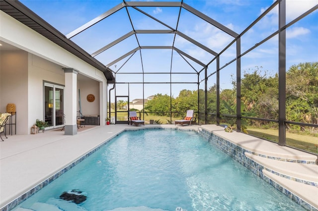 view of pool with pool water feature, glass enclosure, and a patio area