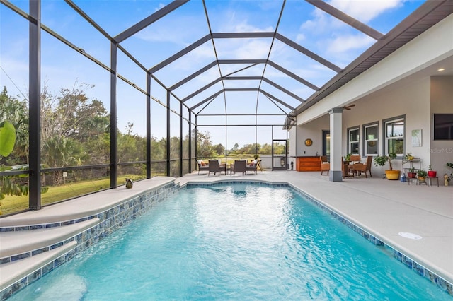 view of swimming pool featuring pool water feature, a patio area, and a lanai