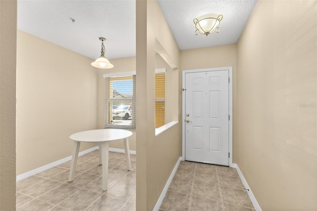 entryway featuring light tile patterned flooring and a textured ceiling