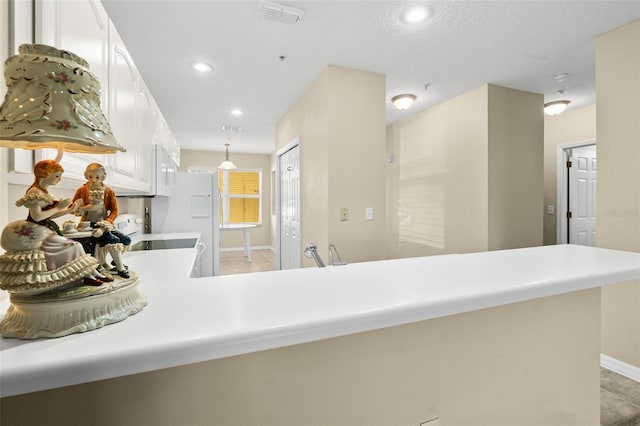 kitchen featuring white cabinets, stove, kitchen peninsula, and sink