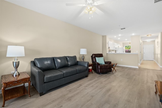 living room featuring ceiling fan and light hardwood / wood-style flooring