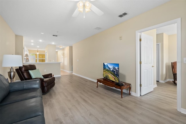 living room featuring light hardwood / wood-style floors and ceiling fan