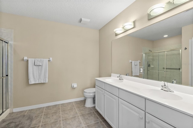 bathroom with vanity, a shower with door, tile patterned flooring, toilet, and a textured ceiling