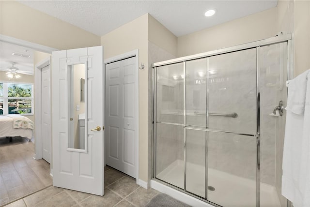 bathroom with walk in shower, wood-type flooring, a textured ceiling, and ceiling fan