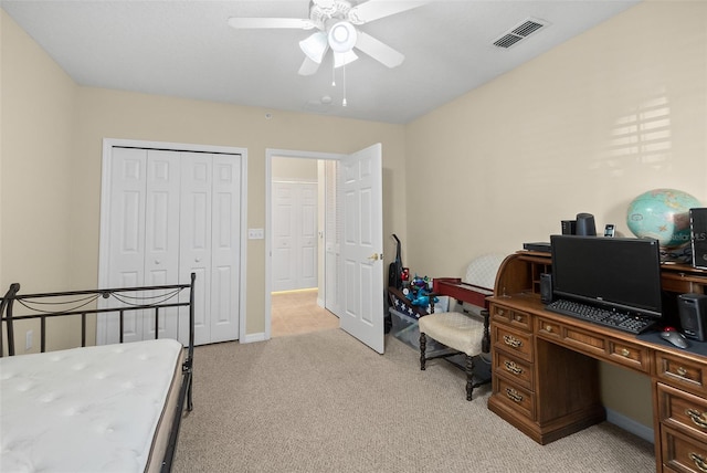 bedroom featuring ceiling fan, light colored carpet, and a closet