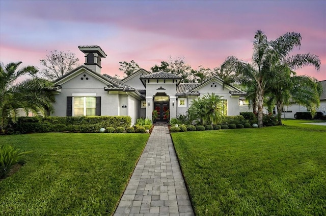 mediterranean / spanish-style home with a lawn