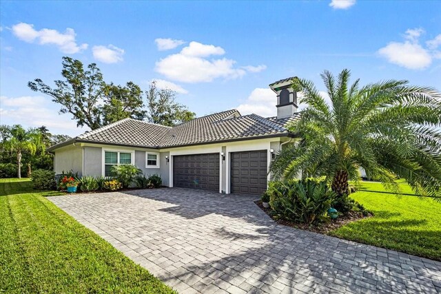 mediterranean / spanish house featuring a front lawn and a garage