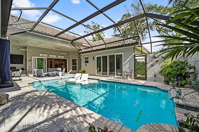 view of swimming pool with a lanai, ceiling fan, pool water feature, and a patio