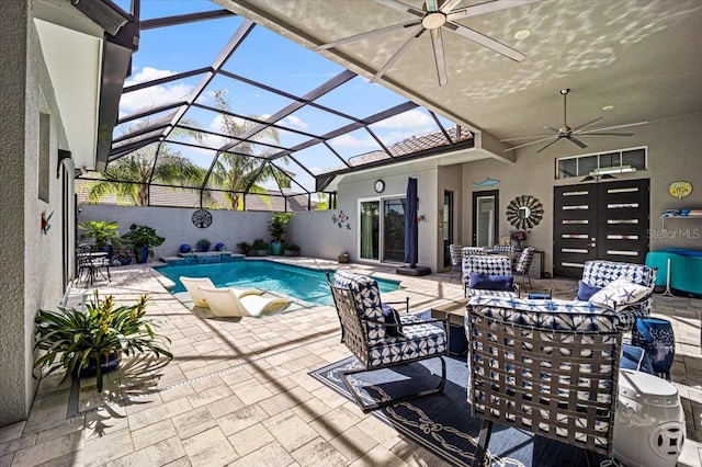 view of pool with outdoor lounge area, a patio area, ceiling fan, and a lanai