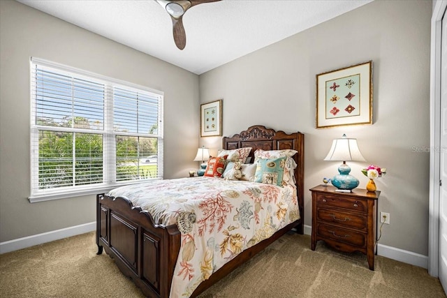 bedroom with multiple windows, ceiling fan, and light colored carpet