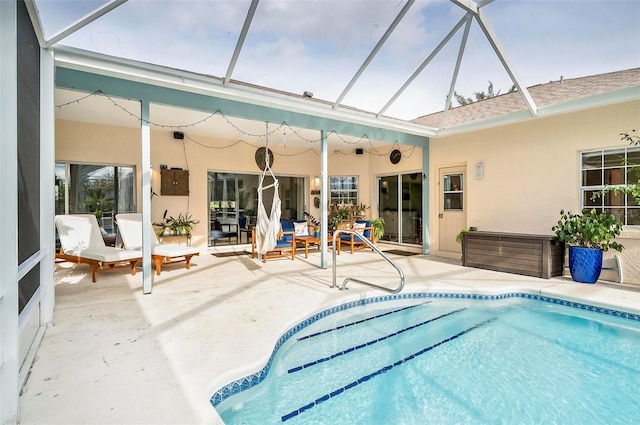 view of pool featuring glass enclosure and a patio