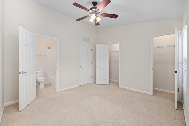 unfurnished bedroom featuring light carpet, ceiling fan, ensuite bathroom, and vaulted ceiling