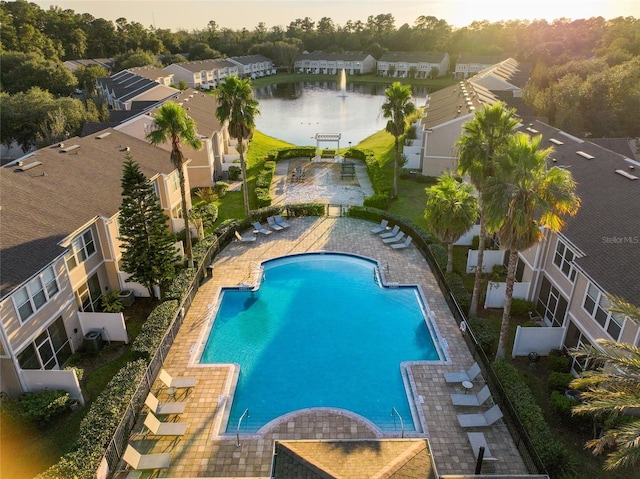 view of pool featuring a water view and a patio