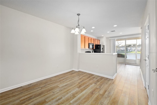 kitchen featuring stainless steel fridge with ice dispenser, an inviting chandelier, kitchen peninsula, and light hardwood / wood-style flooring