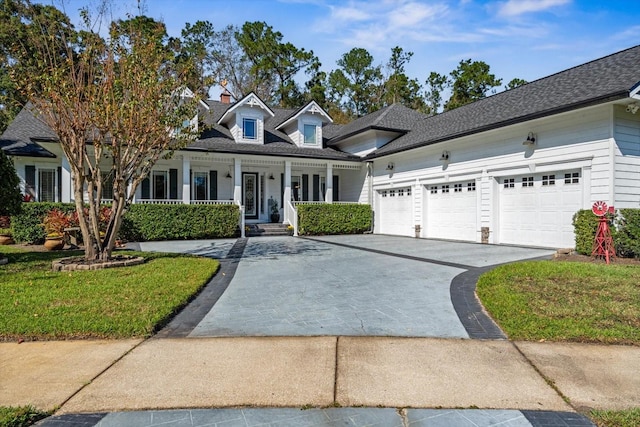 view of front of property featuring covered porch, a front yard, and a garage