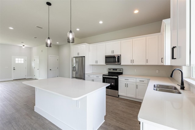 34 Bannbury Ln, Palm Coast, FL 32137 - kitchen featuring hardwood / wood-style floors, a center island, white cabinets, sink, and stainless steel appliances
