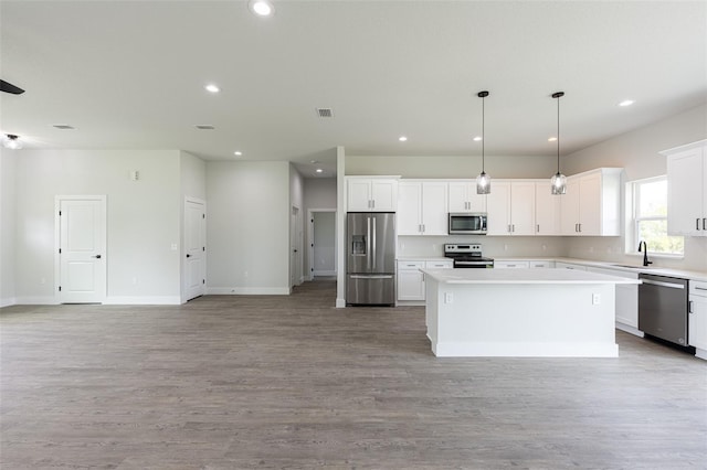 34 Bannbury Ln, Palm Coast, FL 32137 - kitchen with a center island, light wood-type flooring, hanging light fixtures, and appliances with stainless steel finishes