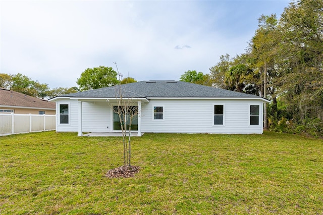 back of property with a yard and a patio area