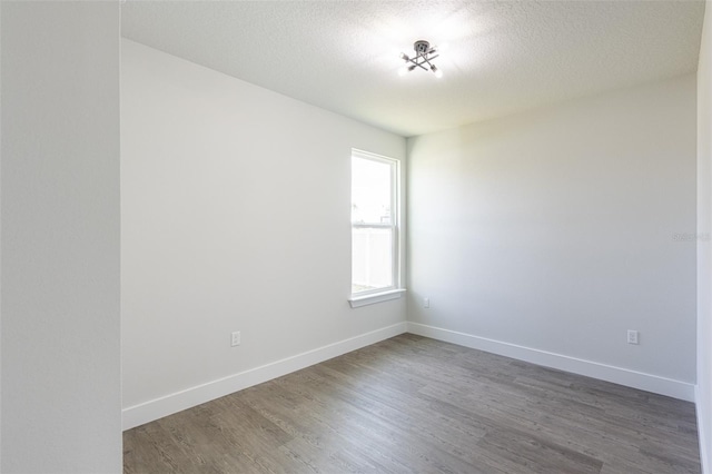 unfurnished room featuring dark hardwood / wood-style flooring and a textured ceiling