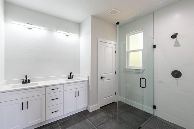 bathroom with tile patterned floors, a shower with door, and vanity