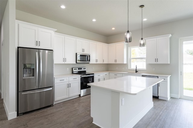 kitchen with white cabinets, plenty of natural light, a kitchen island, and stainless steel appliances