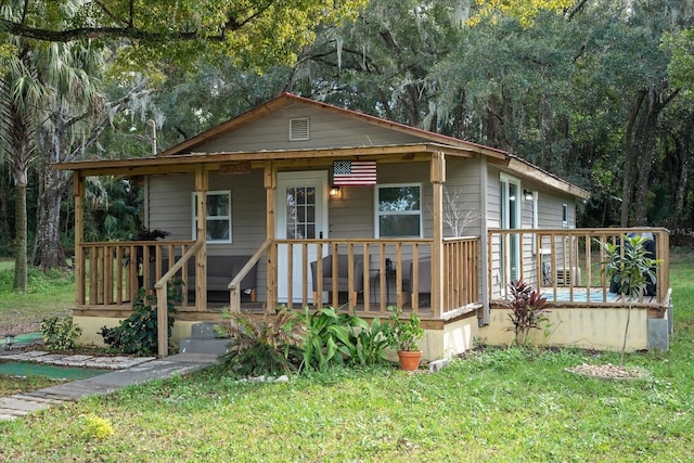 bungalow-style home featuring covered porch and a front yard