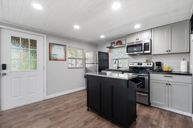 kitchen featuring a center island, stainless steel appliances, dark wood-type flooring, and sink