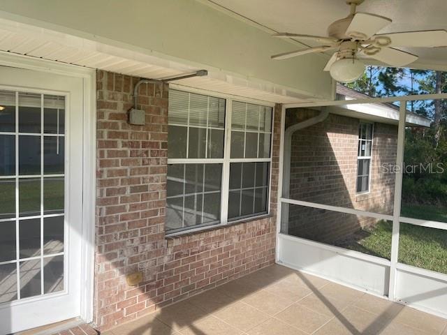 unfurnished sunroom featuring ceiling fan