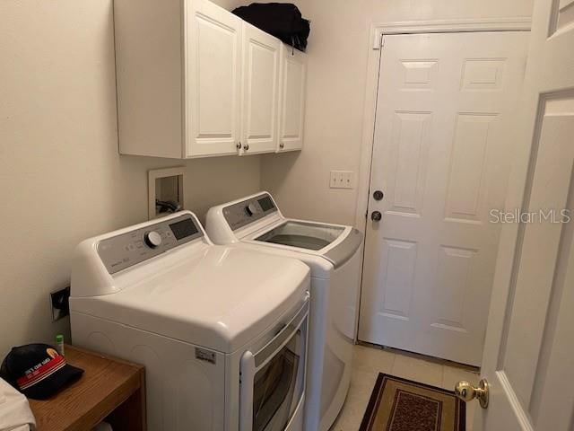 laundry room with cabinets, separate washer and dryer, and light tile patterned flooring