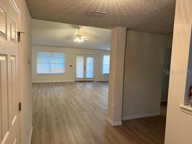 interior space featuring hardwood / wood-style floors, a textured ceiling, and french doors