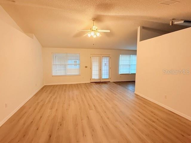 unfurnished living room with ceiling fan, light hardwood / wood-style floors, and a textured ceiling