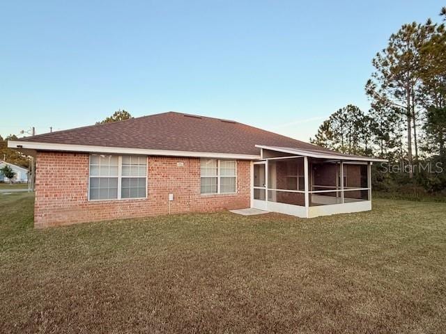 back of house featuring a sunroom and a yard