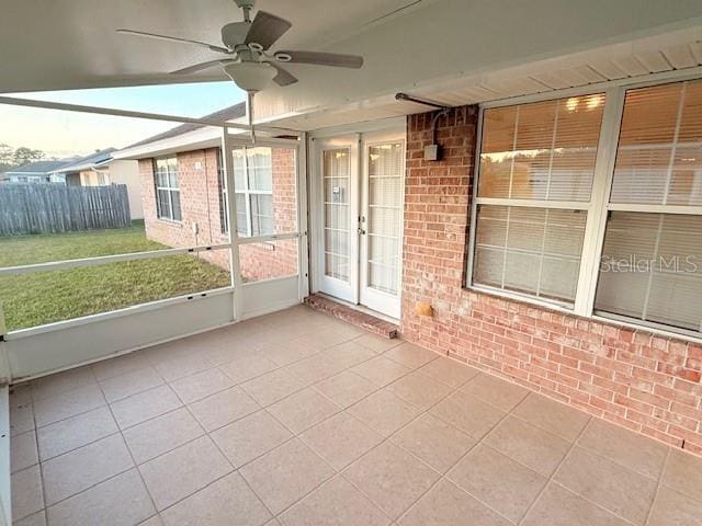 unfurnished sunroom featuring ceiling fan