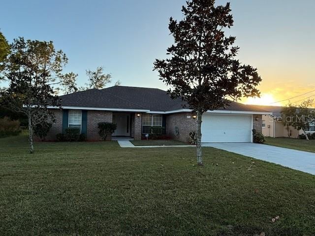 single story home with a lawn and a garage