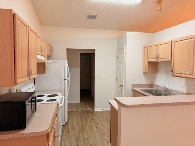 kitchen featuring kitchen peninsula, light brown cabinetry, light wood-type flooring, sink, and electric range