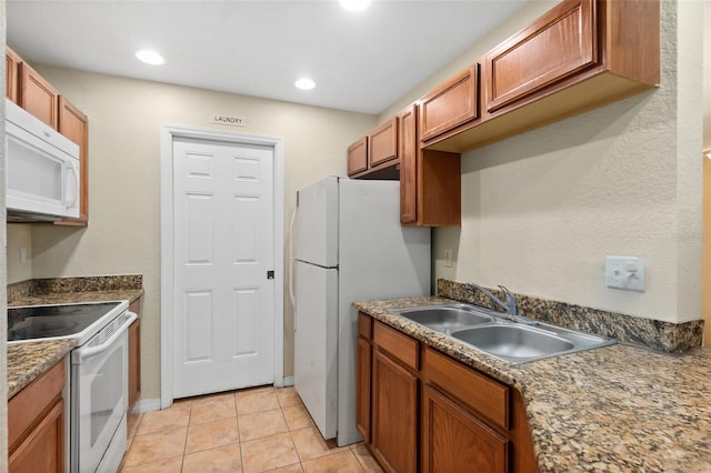 kitchen with light tile patterned floors, white appliances, and sink