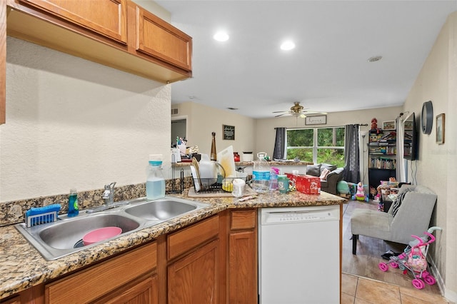 kitchen featuring ceiling fan, sink, light stone countertops, white dishwasher, and light tile patterned floors