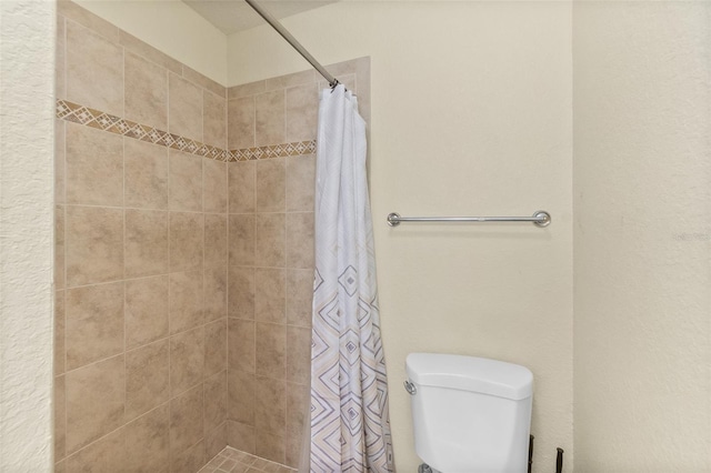 bathroom with a shower with shower curtain and toilet