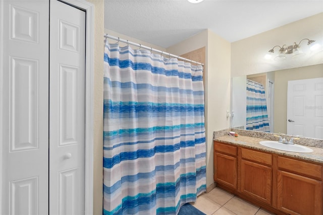 bathroom with a shower with shower curtain, a textured ceiling, vanity, and tile patterned floors