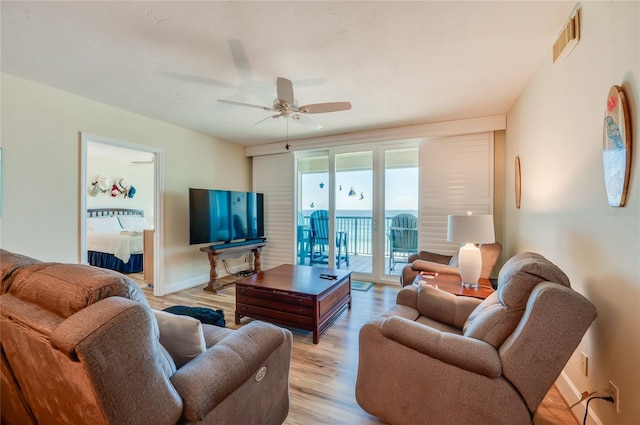 living room featuring ceiling fan and light hardwood / wood-style floors