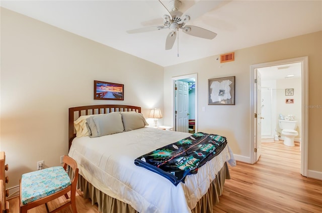 bedroom featuring ceiling fan, a spacious closet, light hardwood / wood-style flooring, and ensuite bath