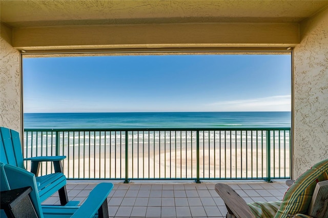 balcony with a water view and a beach view