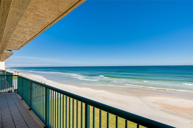 balcony featuring a water view and a beach view