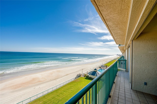 balcony featuring a water view and a beach view